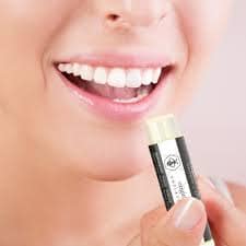 a lady applying lip balm